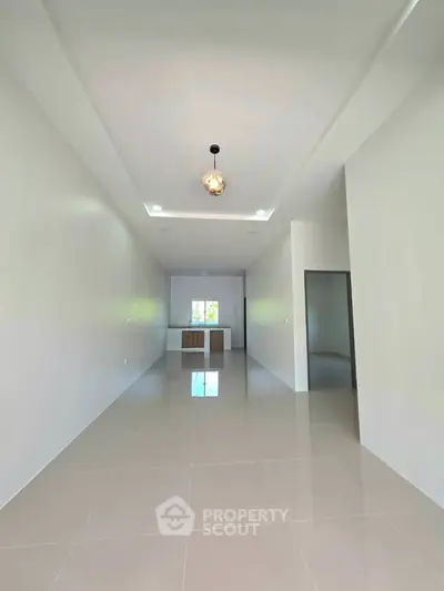 Spacious open-plan living area with modern kitchen and sleek tile flooring