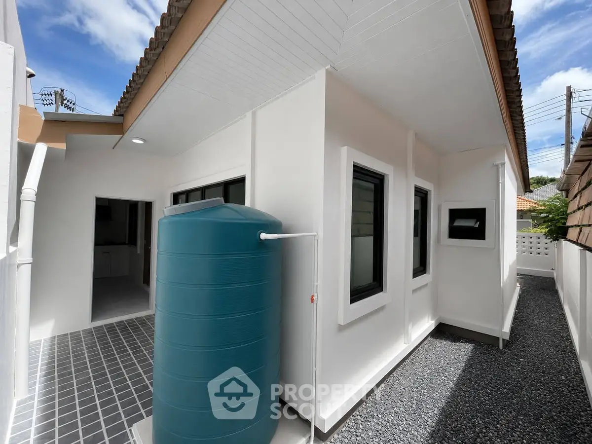 Modern exterior view of a house with a water tank and sleek design.