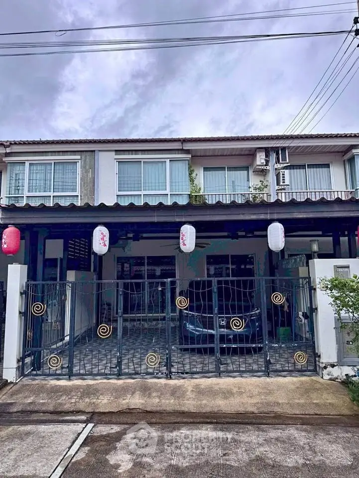 Charming townhouse with gated parking and decorative lanterns, perfect for cozy living.