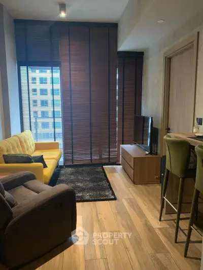 Modern living room with stylish furniture and large windows in a high-rise apartment.
