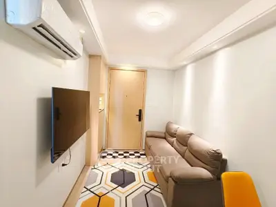 Cozy living room with modern decor and wall-mounted TV in a compact apartment.
