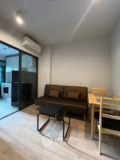 Modern living room with sleek furniture and glass partition in a stylish apartment.