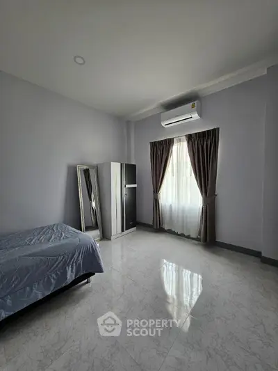 Spacious bedroom with modern decor and natural light