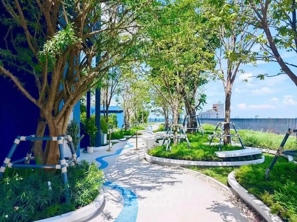 Lush garden pathway with trees and scenic views in a modern residential complex.