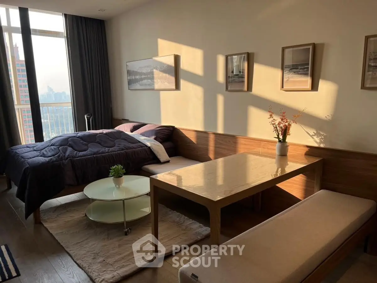 Cozy studio apartment with modern decor and large windows offering city views