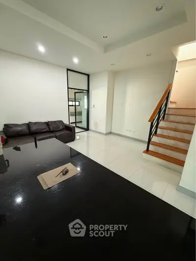 Spacious modern living room with sleek staircase and cozy seating area