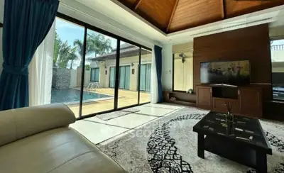 Luxurious living room with pool view, elegant decor, and large windows for natural light.