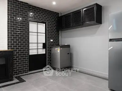 Modern kitchen with sleek black cabinetry and stainless steel appliances