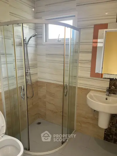 Modern bathroom with glass shower and stylish sink in a contemporary home.