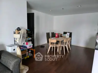 Spacious dining area with wooden flooring and modern furniture in a cozy apartment.