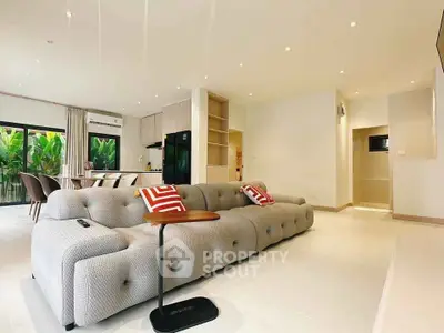 Spacious modern living room with elegant sofa and open kitchen layout