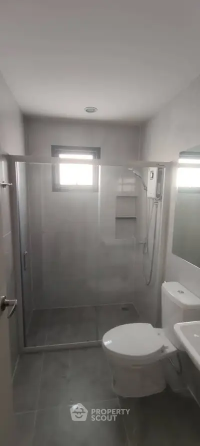 Modern bathroom with glass shower enclosure and sleek fixtures