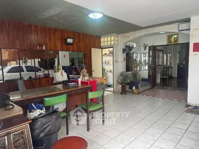 Spacious living area with tiled flooring and wooden accents, perfect for family gatherings.