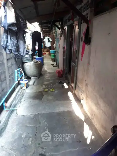 Narrow alleyway with laundry and household items, showcasing rustic urban living.