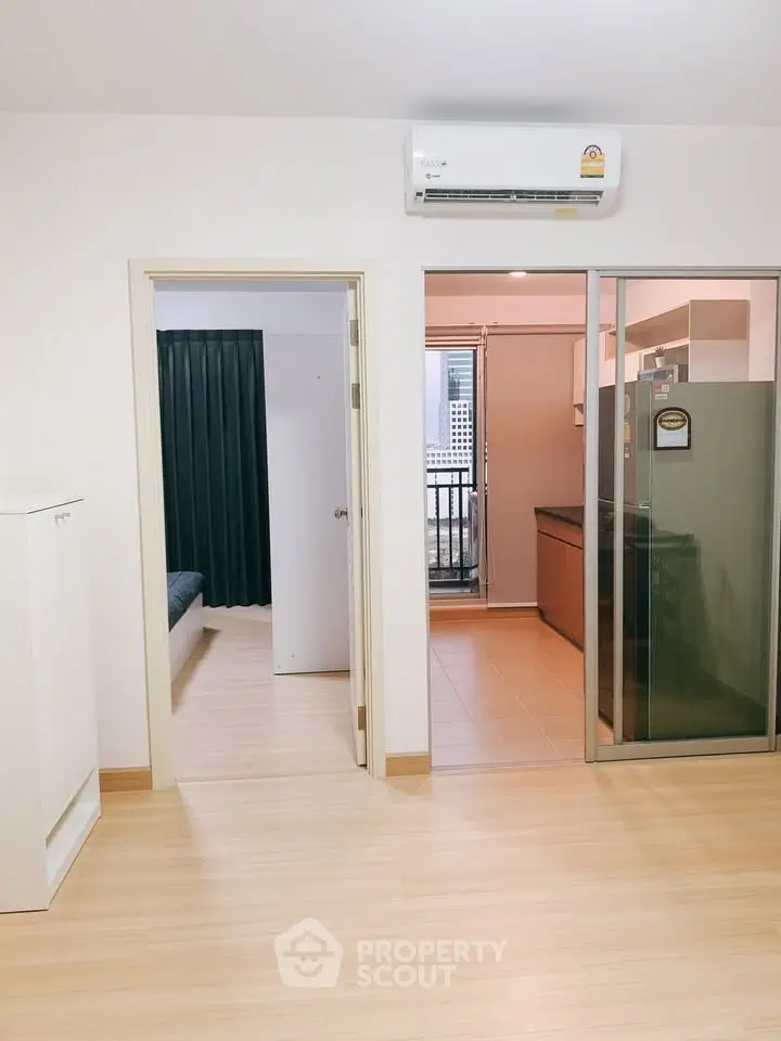 Modern apartment interior with open layout, featuring a sleek kitchen and bright living space.