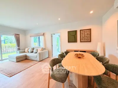 Spacious modern living room with elegant dining area and large windows for natural light.