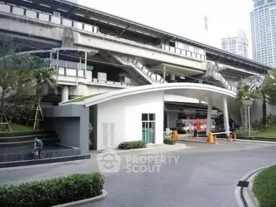 Modern building entrance with sleek design and lush greenery