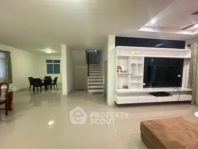 Spacious modern living room with sleek entertainment center and dining area