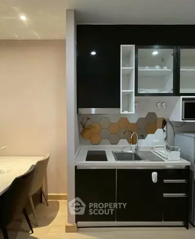 Modern kitchen with sleek black cabinets and hexagonal backsplash tiles