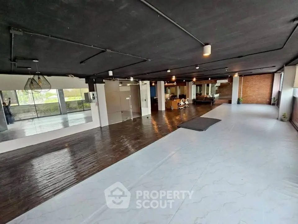 Spacious open-plan interior with modern design and wooden flooring, ideal for versatile use.