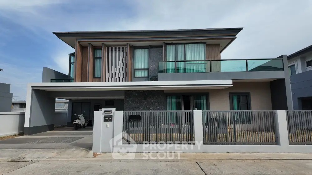 Modern two-story house with sleek design and spacious balcony in suburban neighborhood.