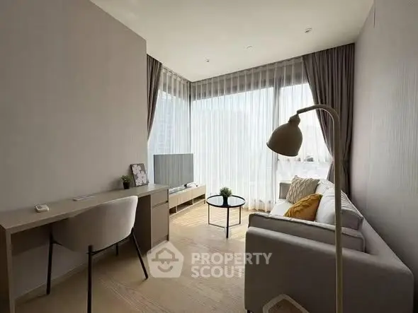 Modern living room with natural light, cozy sofa, and stylish decor in a high-rise apartment.