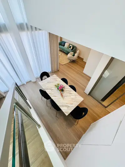 Stunning modern dining area with elegant marble table and high ceilings, perfect for stylish living.
