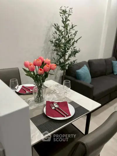 Elegant dining area with tulip centerpiece and cozy seating, perfect for intimate gatherings.