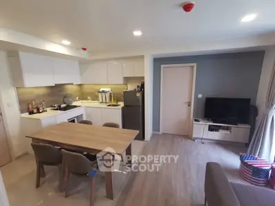 Modern open-plan kitchen and living area with stylish dining set and sleek appliances.