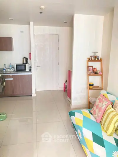 Cozy living room with colorful sofa and compact kitchen area