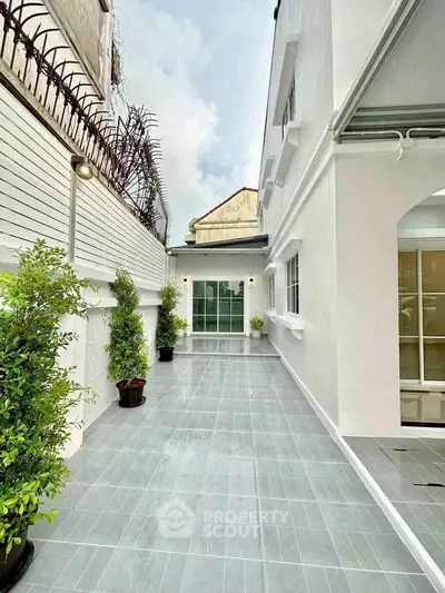 Spacious modern exterior with sleek tiled pathway and lush greenery