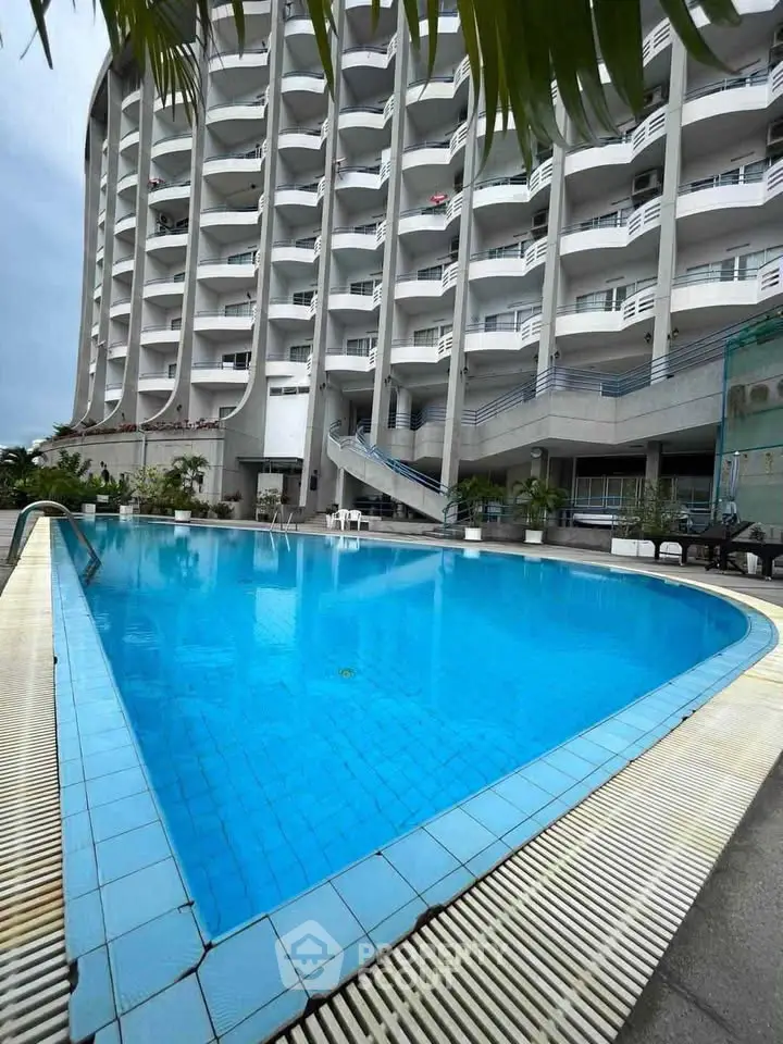Luxurious high-rise building with stunning poolside view and modern architectural design.