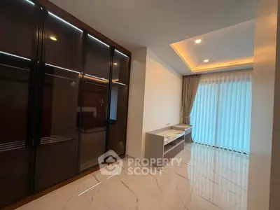 Spacious modern living room with elegant marble flooring and large windows for natural light.
