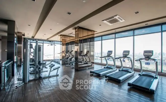 Luxurious high-rise gym with panoramic city views and modern fitness equipment.