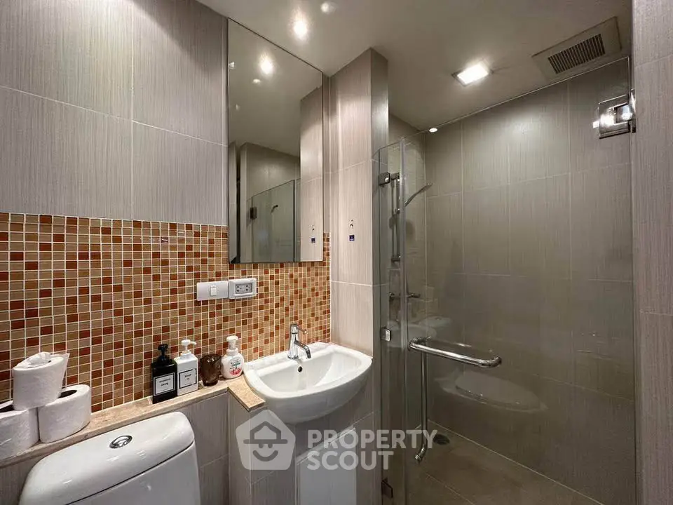 Modern bathroom with sleek design, glass shower, and stylish tile accents.