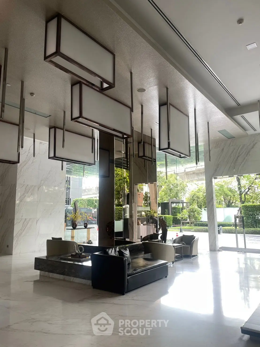 Luxurious modern building entrance with stylish seating and elegant lighting fixtures.