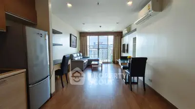 Spacious modern living room with city view, featuring sleek furniture and natural light.