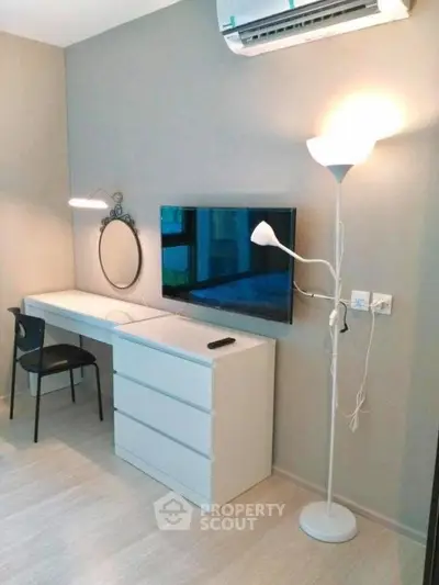 Modern study area with sleek desk, wall-mounted TV, and stylish lighting in a contemporary apartment.