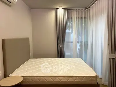 Modern bedroom with large window and elegant curtains, featuring a comfortable bed and minimalist decor.