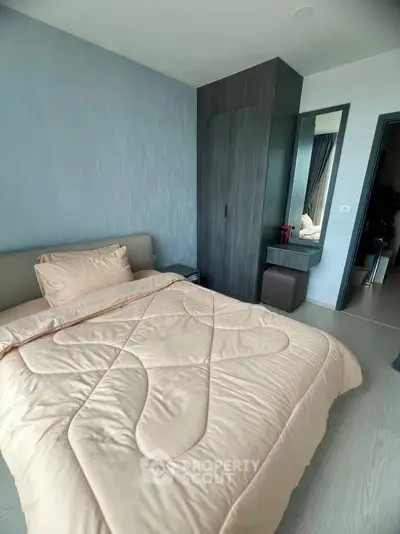 Modern bedroom with stylish wardrobe and cozy bedding in a contemporary apartment.