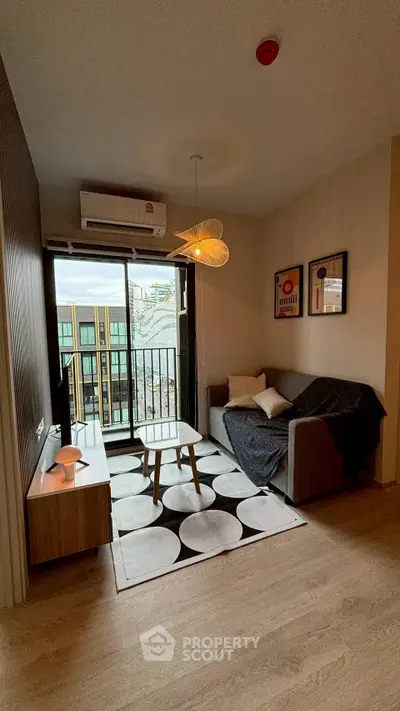 Modern living room with stylish decor and balcony view in urban apartment.
