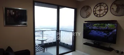 Modern living room with balcony view and wall-mounted TV, featuring stylish decor and cityscape backdrop.