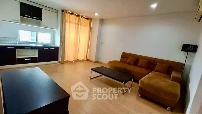 Spacious living room with modern kitchen and cozy sofa in open layout apartment.