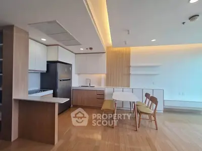 Modern kitchen with open layout, sleek cabinetry, and dining area in a stylish apartment.