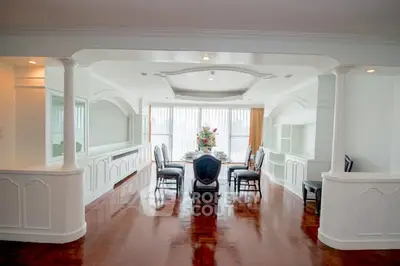 Elegant dining room with polished wooden floors and large windows offering natural light.