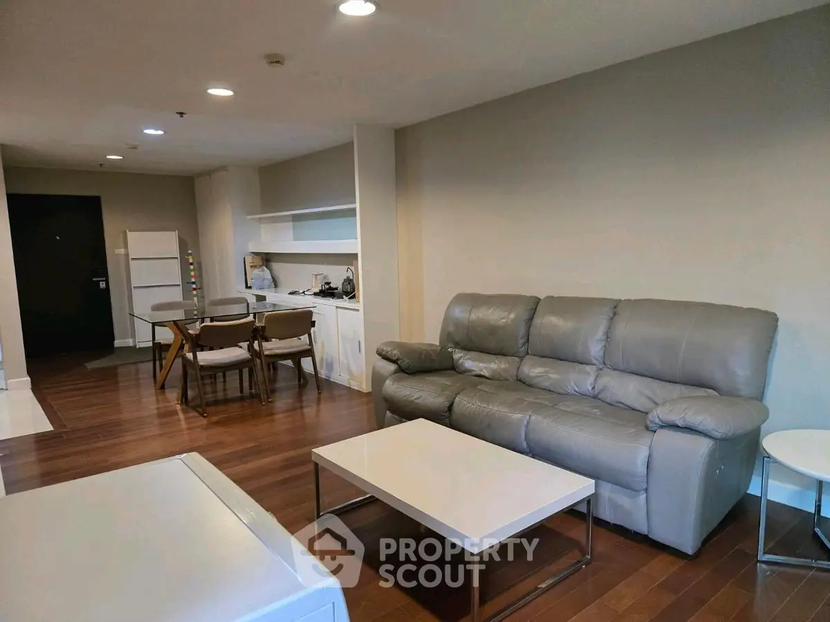 Spacious living room with modern furniture and open kitchen layout.