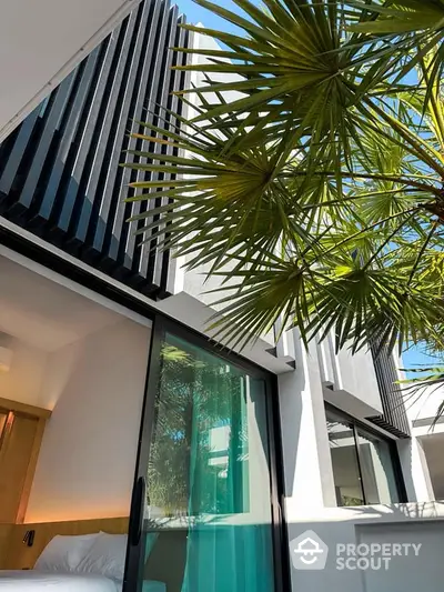 Modern architectural exterior with sleek design and lush palm tree view