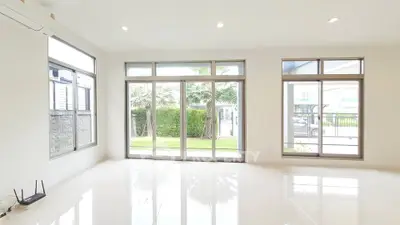 Spacious modern living room with large windows and garden view, perfect for natural light lovers.