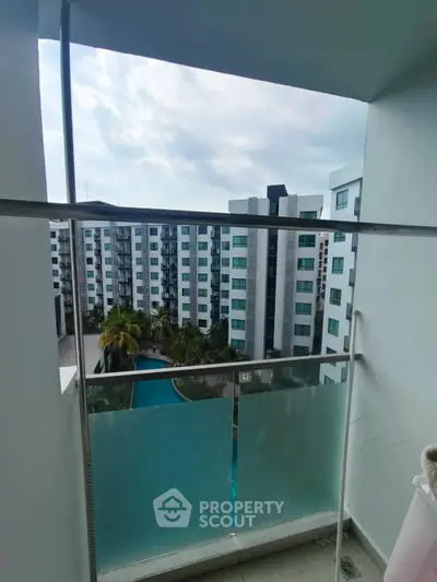Modern apartment balcony with pool and garden view in urban setting