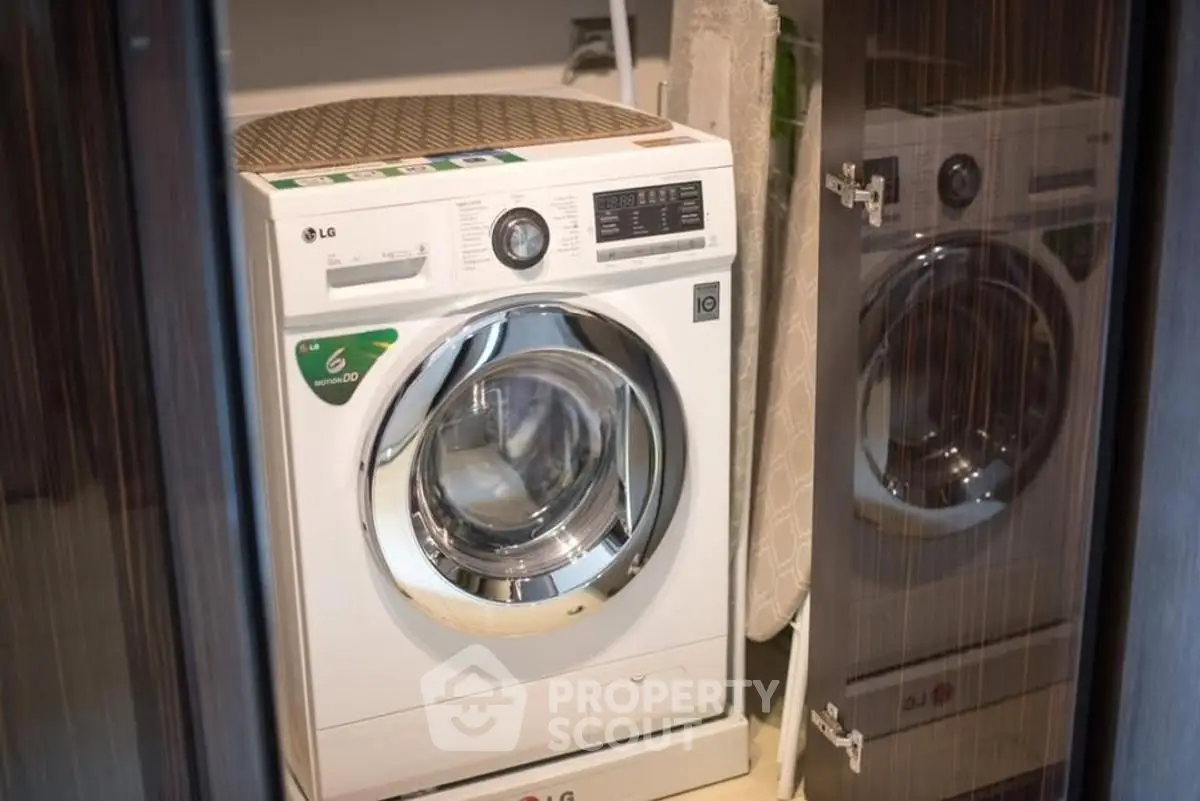 Modern washing machine in sleek laundry area with reflective surfaces